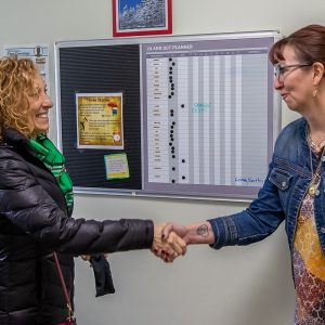 Two women shake hands