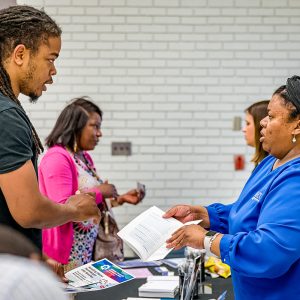 People standing at an event table talking