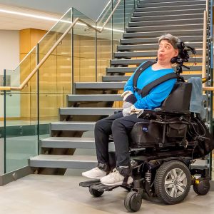 Woman in a wheelchair at the bottom of a staircase