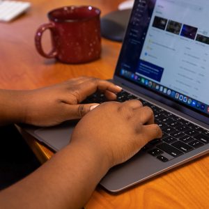 Hands typing on laptop