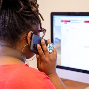 Woman talks on phone and looks at a computer