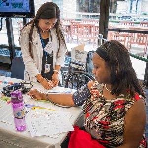 Health care worker measures a woman's blood pressure