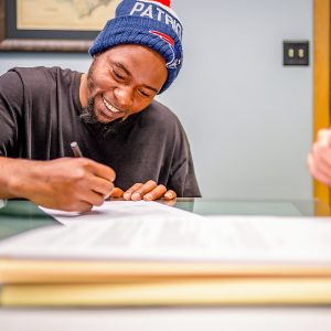 Man sits at table and writes on documents