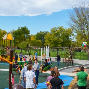 Grand opening of an accessible outdoor park with many kids using the equipment