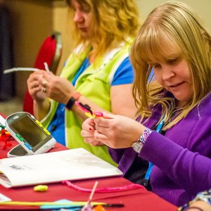 Woman sculpting craft pipe cleaners at an event