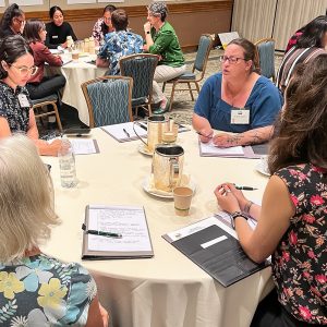 People sitting at round tables at an event