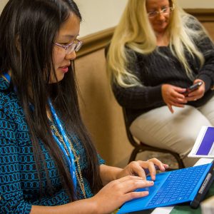 Woman typing on laptop at event