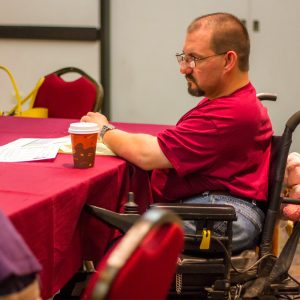 Man in a wheelchair sitting at a table